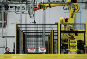 STRONG ARM An Electrolux employee operates a robotic arm at the company’s new 750,000-square-foot manufacturing plant in Memphis.